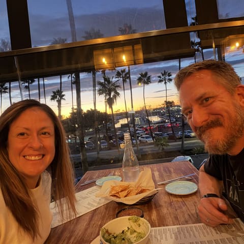 Jenn and Geoff at dinner overlooking the water at sunset